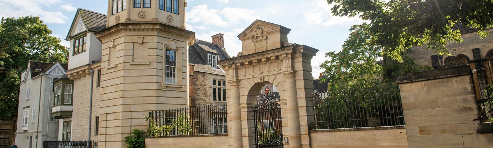 Landscape image portraying a clocktower, entrance to the College and buildings