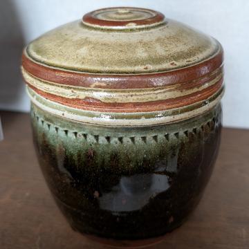 Batterham A ginger pot with lid and green glaze on the body. Around the rim there is a small triangular pattern.
