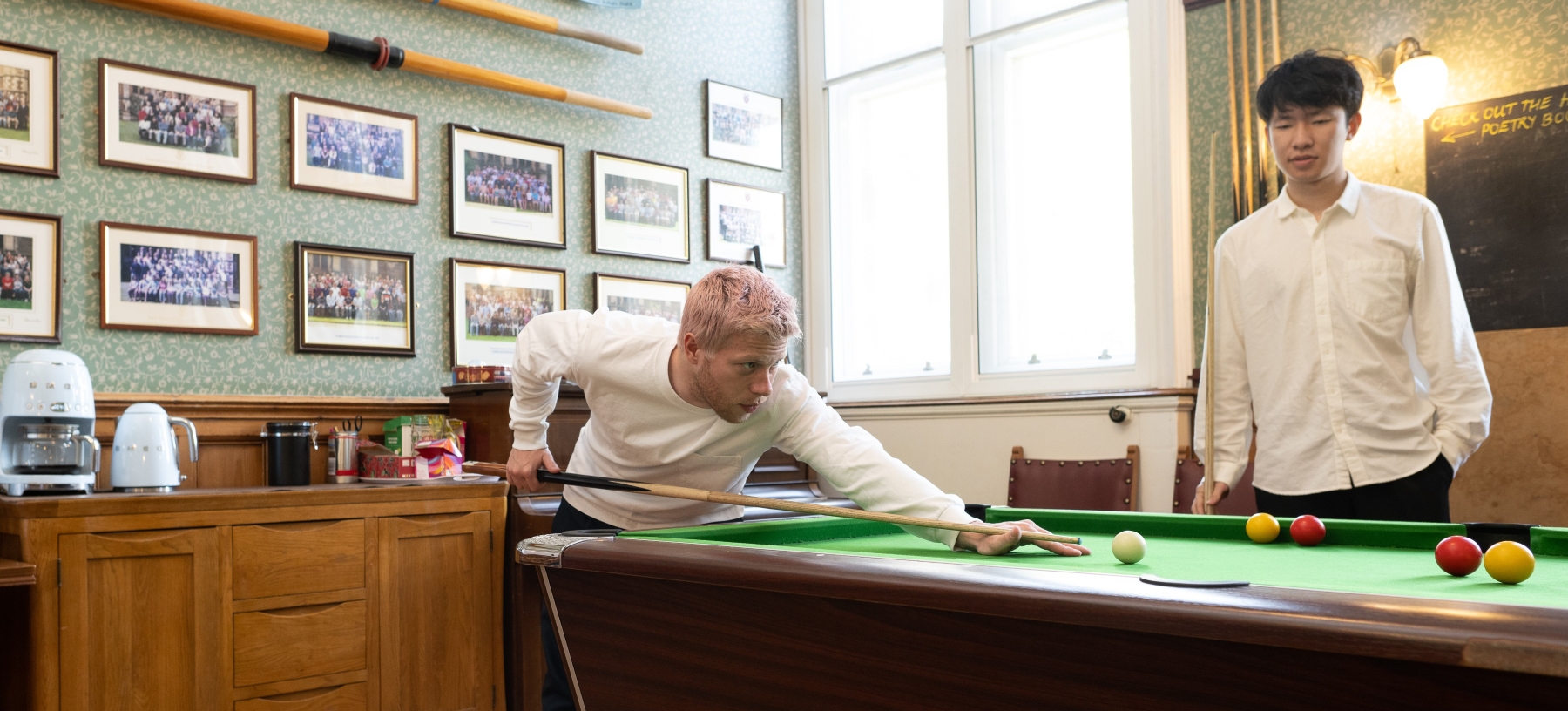 Two students playing pool
