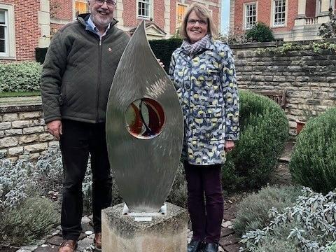 A man and a woman visiting the sculpture, 'Kindle', in the College quad. 