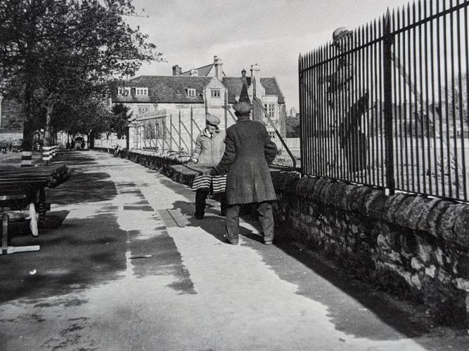 Two men moving a large metal railing from a wall