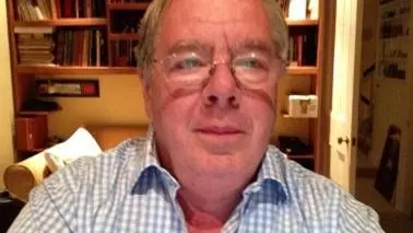 Headshot of a man with glasses in a checked shirt  
