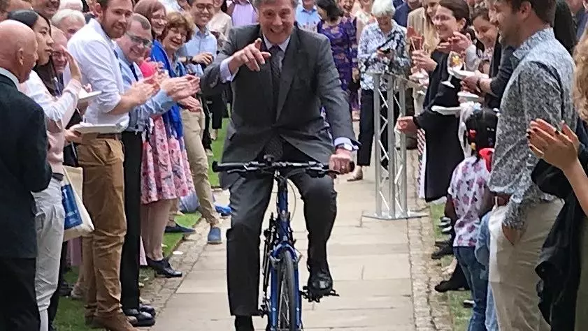 Ralph Waller on bicycle in college quad