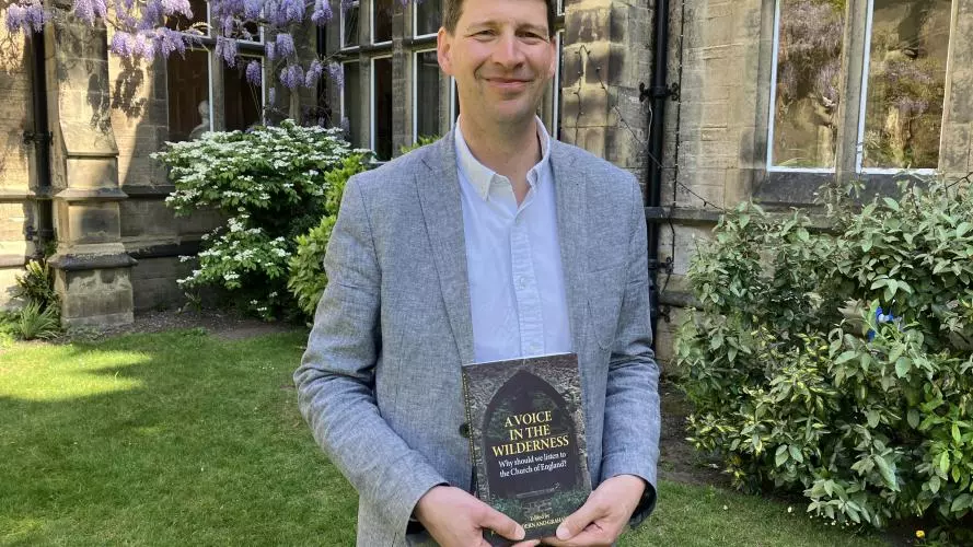 Professor Joshua Hordern holding book