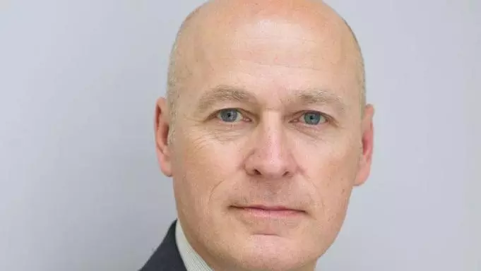 Headshot of a man in a suit with tie