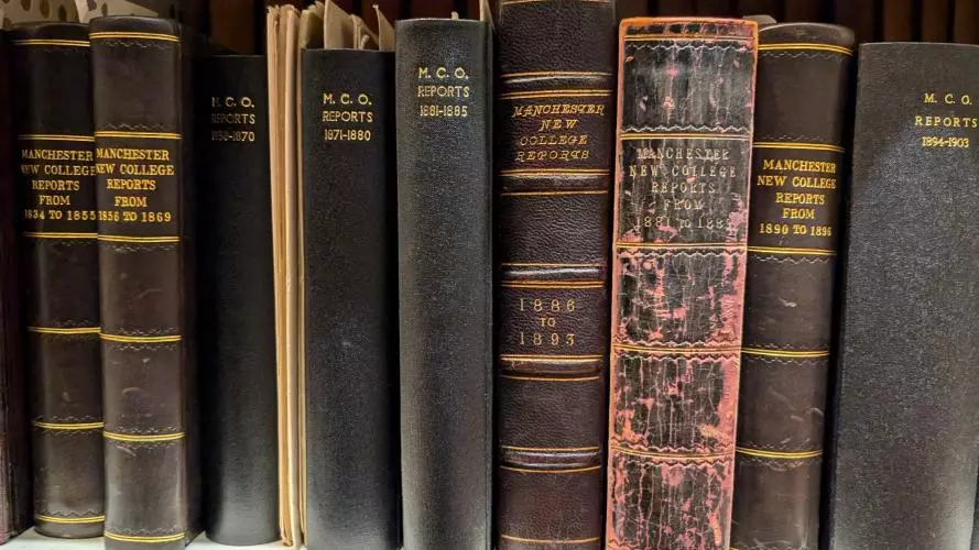 A row of black bound volumes on a shelf with the title MCO reports