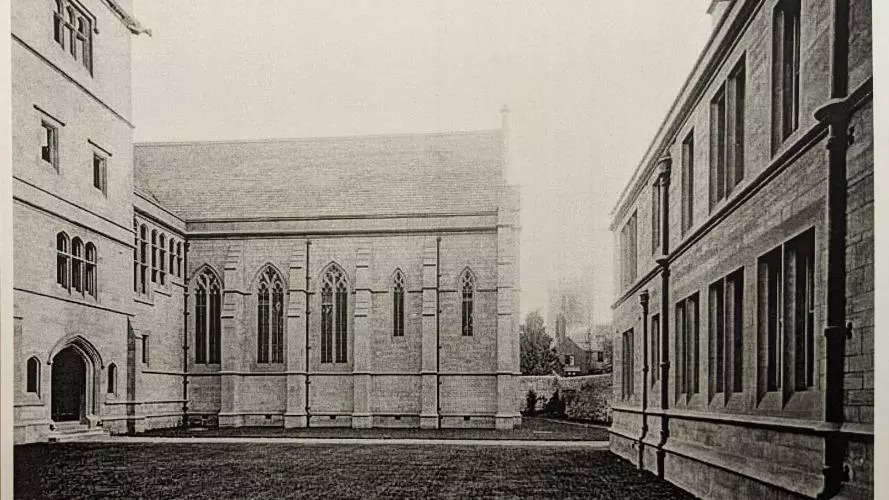 A black and white photograph of the Tate Quad with the stonework looking very bright and new.  There are no plants and the lawns look just laid.