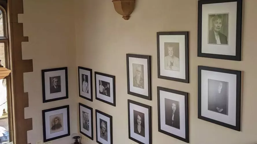 A closer view of the Women Who Made (Harris) Manchester College portraits, mounted on the wall. 