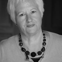 ​  Black and white photograph of a female.  Head and shoulders shot. 