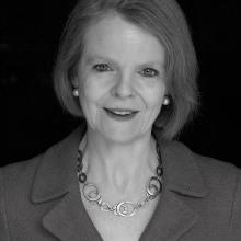 ​  Black and white photograph of a female.  Head and shoulders shot. 