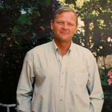 Picture of a man looking relaxed in a garden setting 