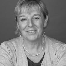 ​  Black and white photograph of a female.  Head and shoulders shot. 