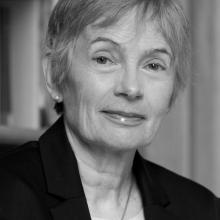 ​  Black and white photograph of a female.  Head and shoulders shot. 