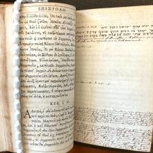 An open double page with Greek on one side and annotations in script on the other