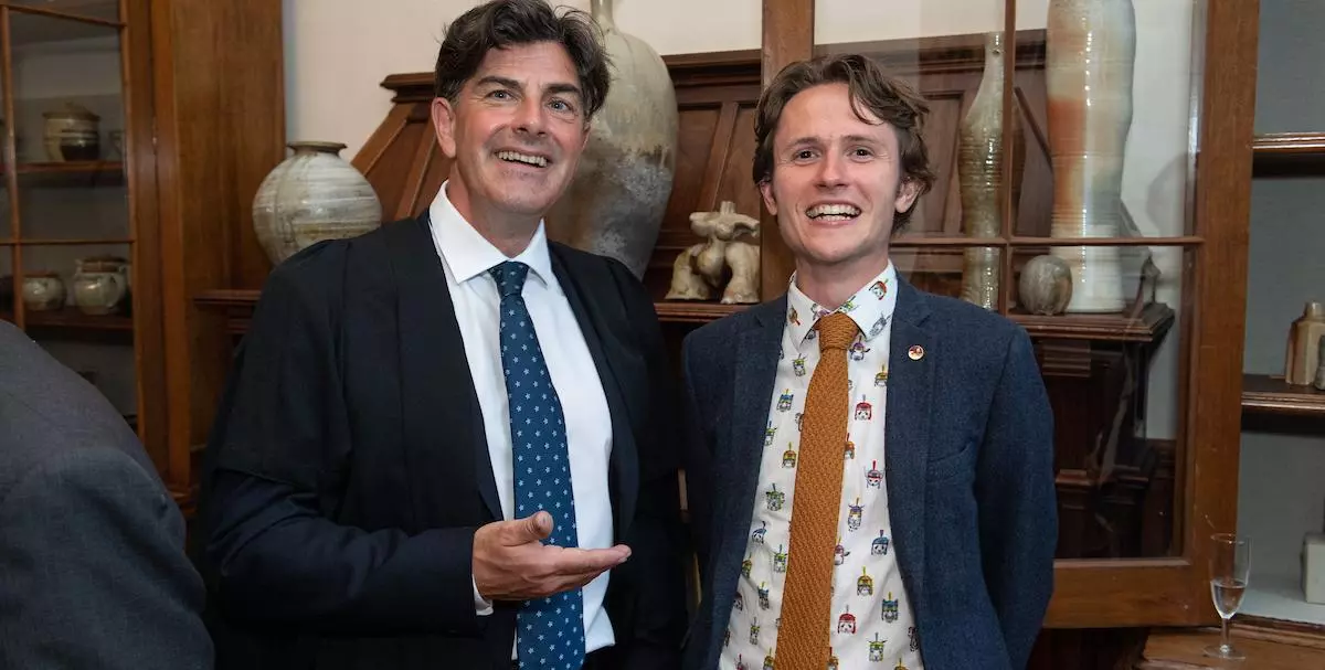 Dr Robin Wilson and Callum Forbes, curators of the exhibition, with a selection of anagama pots behind them.