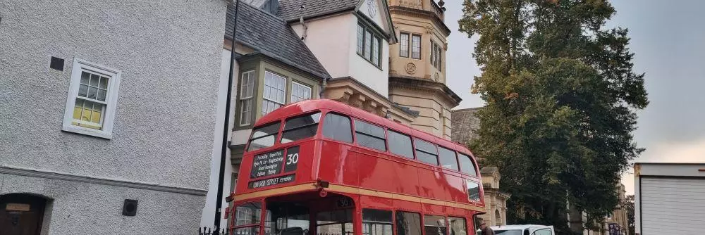 A vintage double-decker bus outside Harris Manchester College