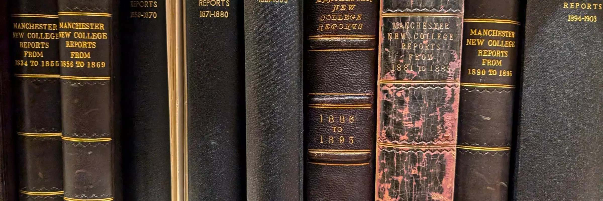 A row of black bound volumes on a shelf with the title MCO reports