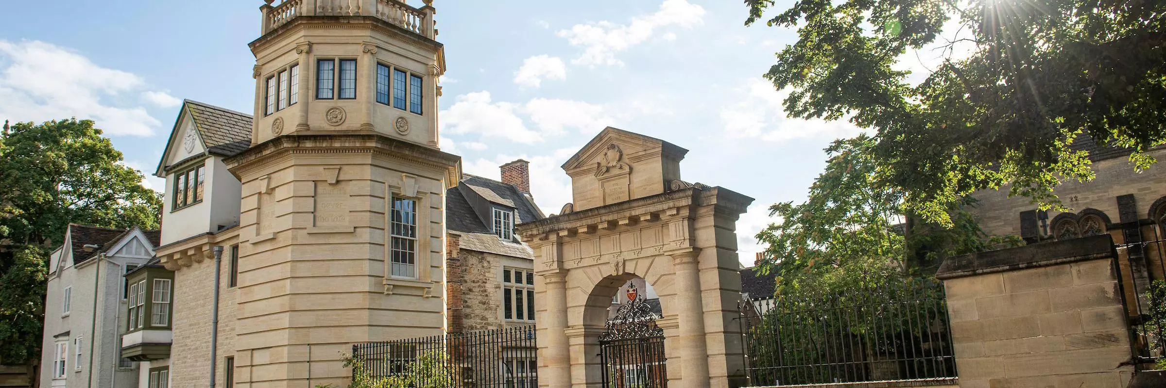 Landscape image portraying a clocktower, entrance to the College and buildings