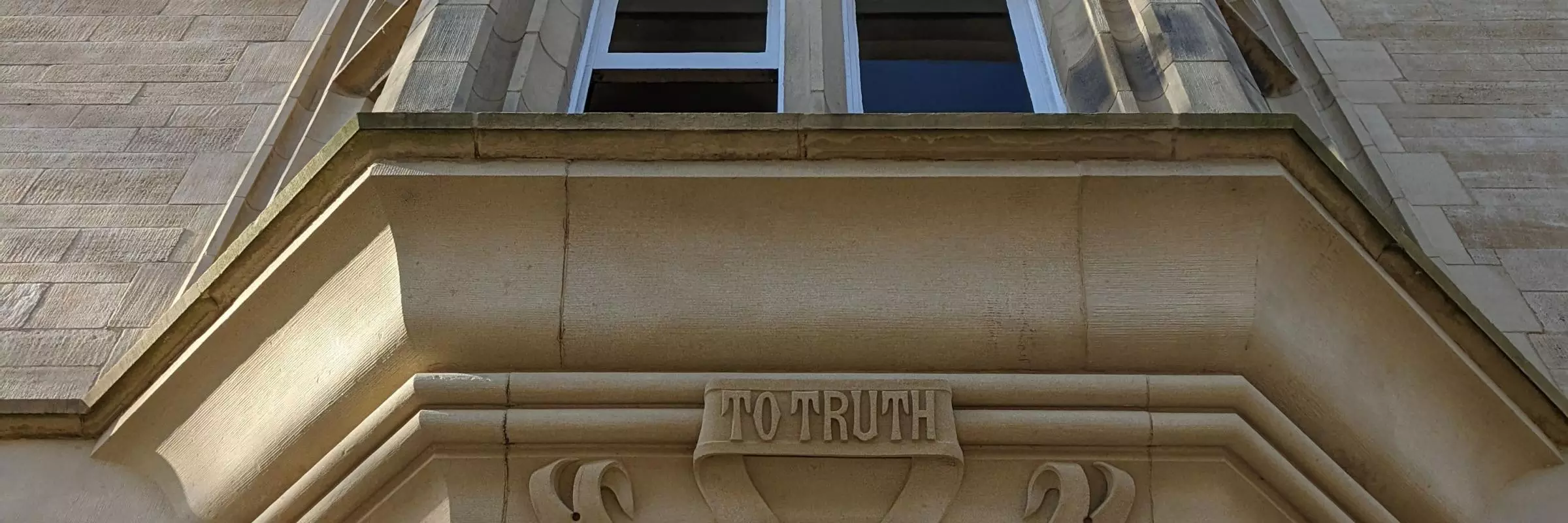 An upward shot of the foundation stone above the main entrance doorway which displays the College motto - To Truth, To Liberty, To Religion