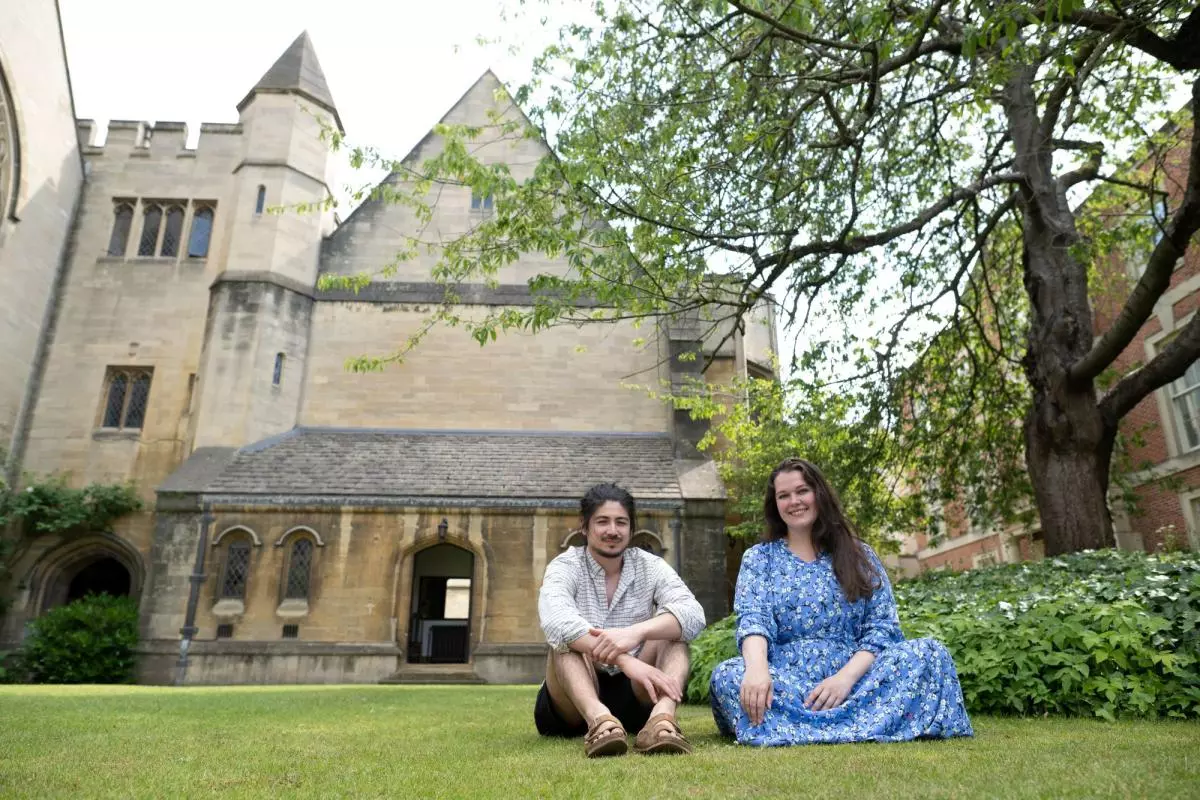 Two students sitting in the quad